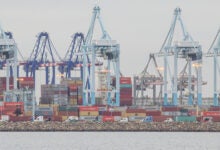 Image shows container cranes and containers dockside at the Port of Los Angeles.