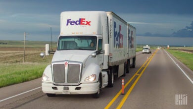 A FedEx Freight truck on the highway, view straight on from the front.