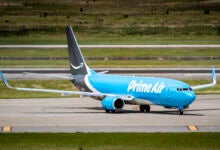A dark-and-light blue Amazon Prime Air cargo jet on the runway.