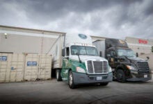 An Old Dominion truck and a UPS Freight truck being loaded at a warehouse