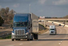 A blue tractor-trailer on a highway