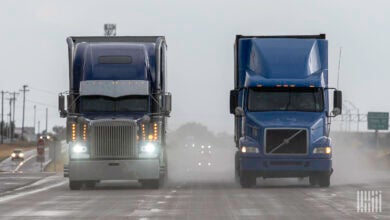 front view of two tractor-trailers on a rain-soaked highway